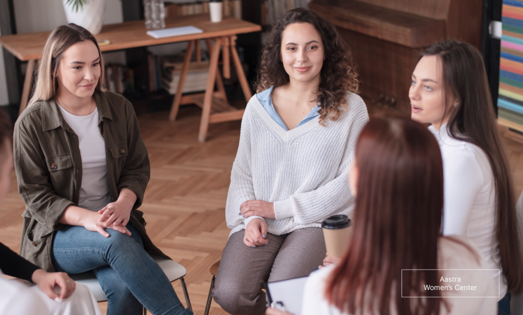 The image shows women talking at an abortion support group.